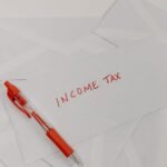 Studio shot of income tax envelope with red pen for accounting and tax season preparation.