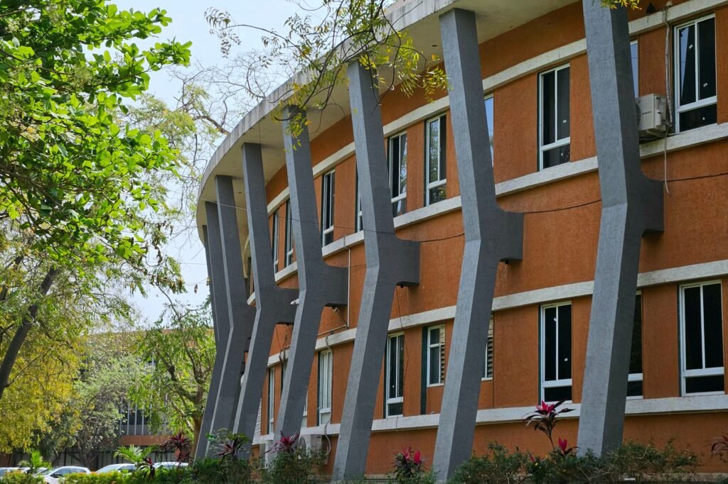 Curved modern building with distinct architectural columns in Ahmedabad, India.