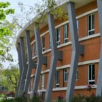 Curved modern building with distinct architectural columns in Ahmedabad, India.