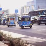 Morning traffic scene in Jakarta featuring diverse vehicles including bajajs and motorcycles.