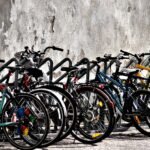 A vibrant display of bicycles parked against a weathered wall in daylight.