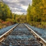 Explore the vibrant fall foliage along a serene railway track in Kirkland Lake, capturing the essence of autumn.