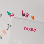 Colorful magnetic numbers scattered around a file labeled 'TAXES', symbolizing financial organization.