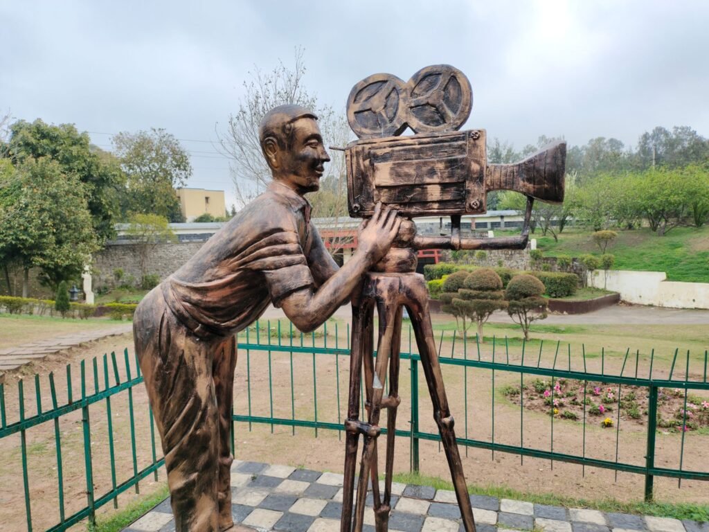 Bronze sculpture of a cameraman with classic camera in a park in Chandigarh, India.