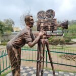 Bronze sculpture of a cameraman with classic camera in a park in Chandigarh, India.