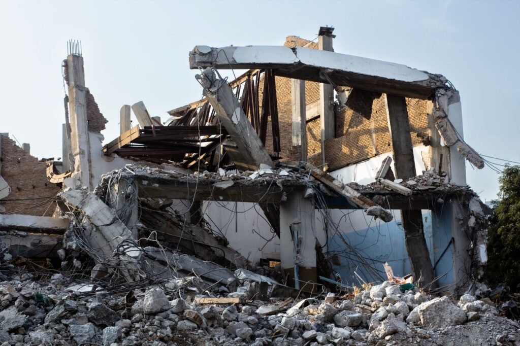 A partially demolished building showcasing exposed beams and rubble at an urban site.