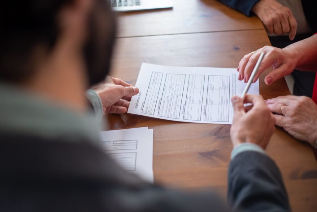 Close-up of business professionals reviewing documents at a meeting.