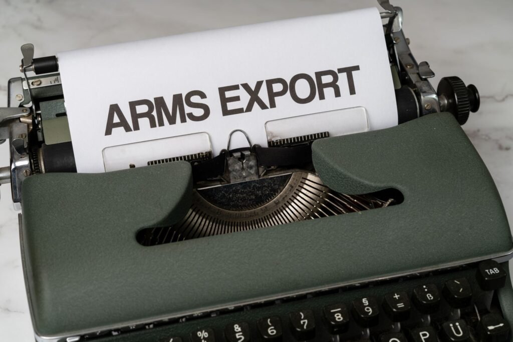 Close-up of a vintage typewriter with the text 'Arms Export' on paper, focusing on journalism and government topics.