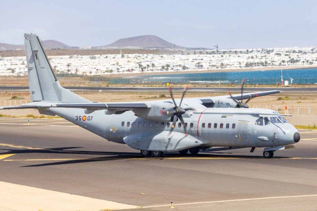 A military aircraft taxiing on a runway in a sunny landscape in Spain.