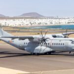A military aircraft taxiing on a runway in a sunny landscape in Spain.