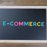 Colorful letters spelling 'e-commerce' on a wooden framed blackboard.