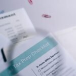 Close-up of tax preparation checklist and income statement with paperclips.