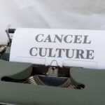 Close-up of a vintage typewriter with paper reading 'Cancel Culture', signifying social media trends.