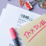 Close-up of IRS Form 1040 with 'Tax Due' note and stationery on a desk.