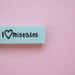 Minimalist eraser with 'I Love Mistakes' message on pink background, school stationery.