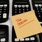 Close-up of calculators and a sticky note labeled 'Tax Season', symbolizing tax preparation.