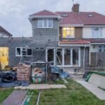 A suburban house undergoing major renovations with scaffolding and building materials.