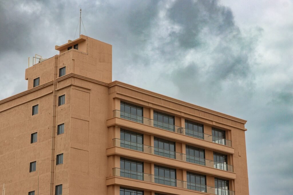 A modern building in Rajkot, Gujarat, India, under a dramatic cloudy sky.