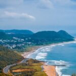 A breathtaking aerial view of the coastline in Visakhapatnam, capturing lush hills and the vibrant sea.