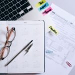 Organized workspace featuring a calendar, tax documents, and planner essentials.