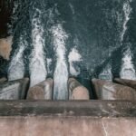 Aerial view of cascading water over a concrete dam showcasing turbulent flow and water management.