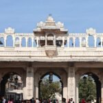 Crowds gather under the ornate gateway of Udaipur City Palace, a historic architectural gem.