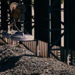 Heavy-duty magnet crane operating in an industrial scrap metal yard.