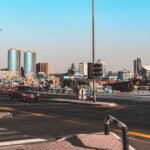 A vibrant street view in Dubai featuring traffic and city skyline with clear skies.