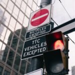 Urban traffic light and signs with building reflection in downtown Toronto.