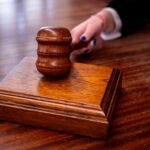 Close-up of a wooden judge's gavel on a desk in a courtroom, symbolizing justice.
