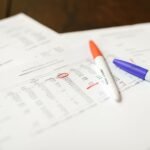 Close-up of financial documents with pens highlighting important data points.