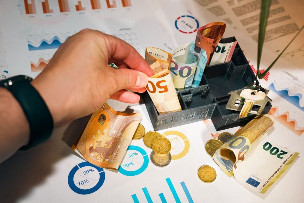 Euro bills and coins with financial charts showcasing budgeting and investment planning.