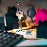 A symbolic representation of real estate finance featuring keys, model houses, and euro banknotes.