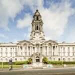 Front view of the iconic Stockport Town Hall with a clear blue sky backdrop.
