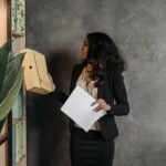 Businesswoman organizing documents in an office setting, demonstrating efficiency and professionalism.