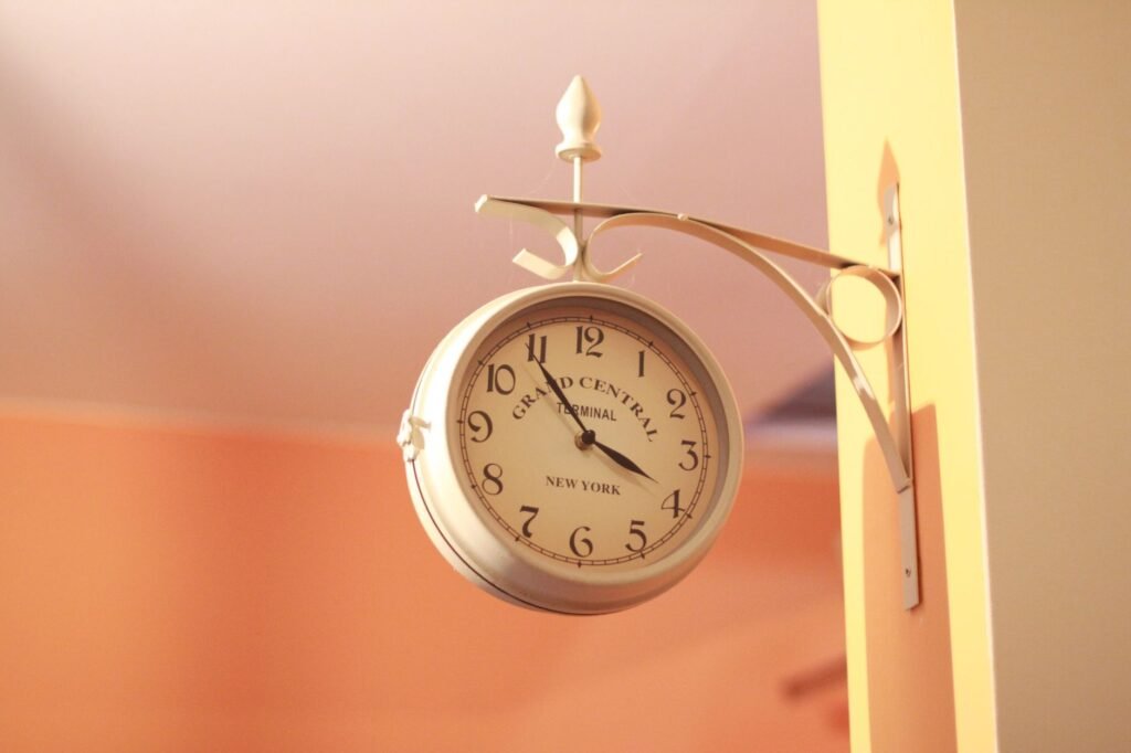 Elegant vintage wall clock mounted on a peach wall, reminiscent of Grand Central Terminal.