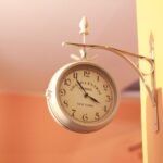 Elegant vintage wall clock mounted on a peach wall, reminiscent of Grand Central Terminal.