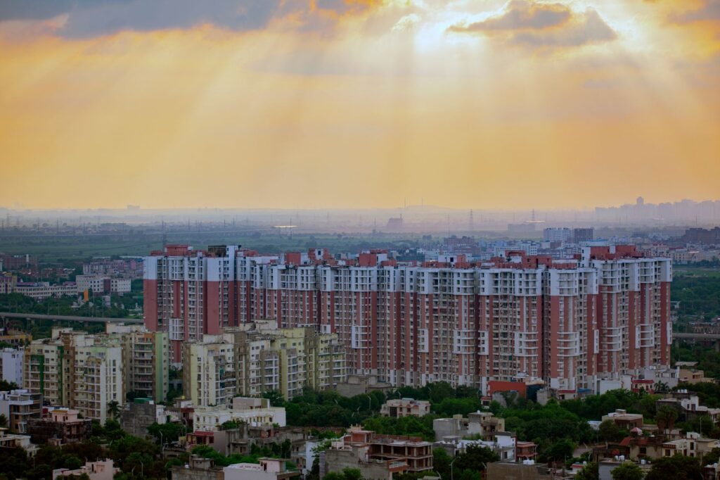 Captivating aerial view of Noida's residential skyline at sunrise, showcasing modern architecture and dramatic skies.