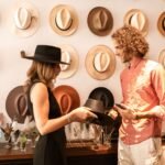 A couple explores hat designs at a chic boutique, selecting chic headwear.