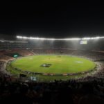 A captivating night cricket match with a large crowd at Narendra Modi Stadium in Ahmedabad, India.
