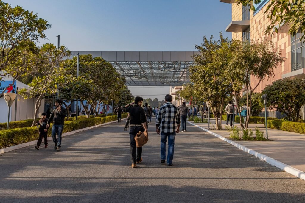A vibrant day at a modern urban street in Greater Noida, UP, India, with people and modern architecture.