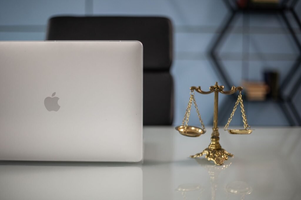 Elegant balance of technology and justice scales on an office desk.