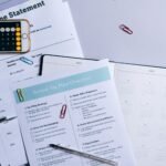Flat lay of a tax preparation checklist, calculator, and financial documents on a desk.