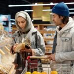 Couple selecting bread in a modern supermarket while grocery shopping together.