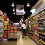 Vibrant supermarket aisle scene with a shopper in Jawa Timur, Indonesia.