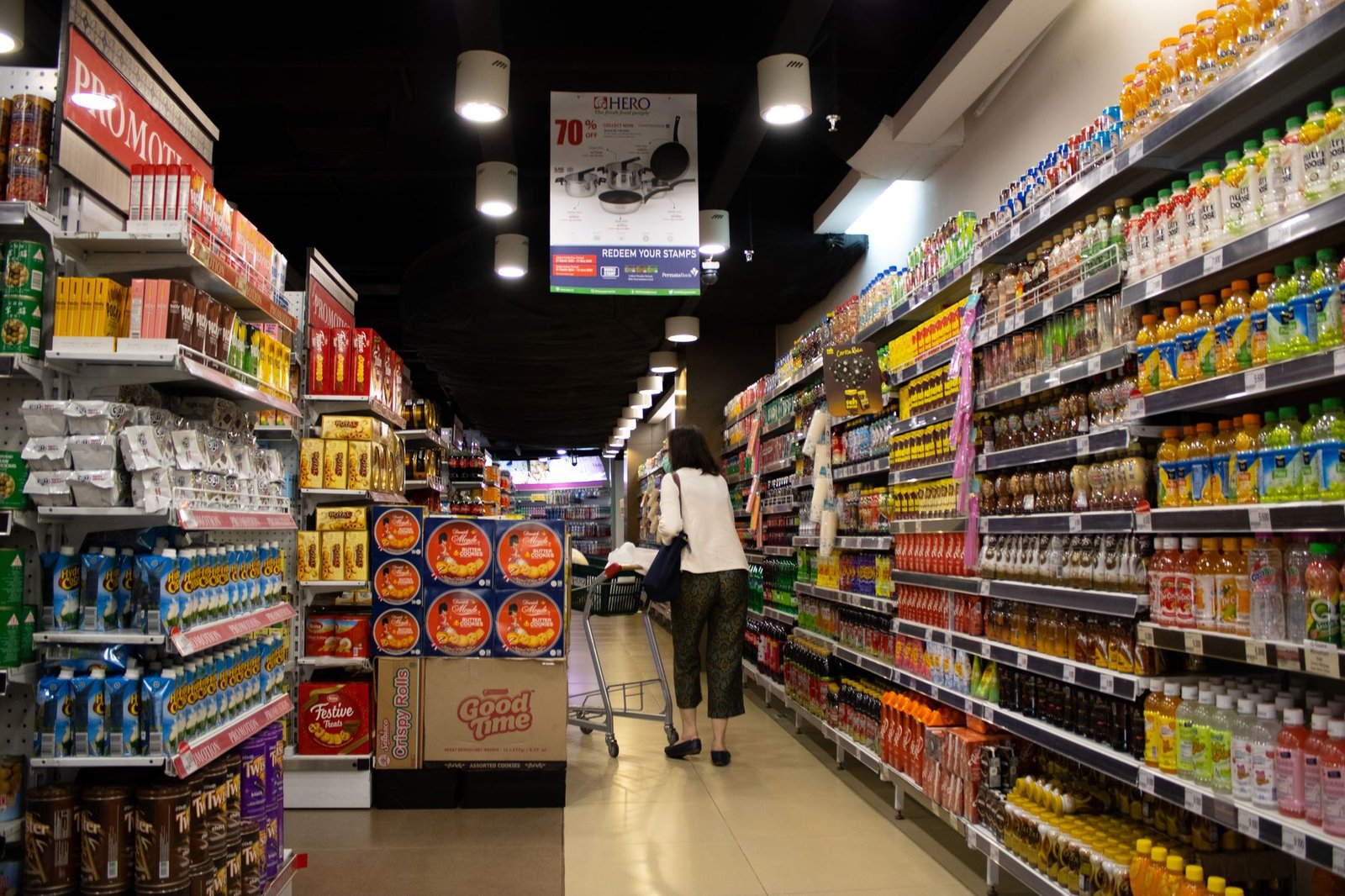 Vibrant supermarket aisle scene with a shopper in Jawa Timur, Indonesia.