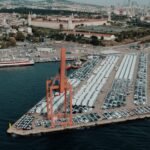 Aerial view of a bustling car shipping terminal in Istanbul, Türkiye, showcasing a busy port with vehicles ready for export.