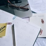 A desk with a planner, sticky note marked 'Tax Deadline', and paperwork, indicating financial planning.