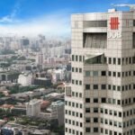 Aerial view of UOB Tower with the sprawling cityscape of Singapore in the background.