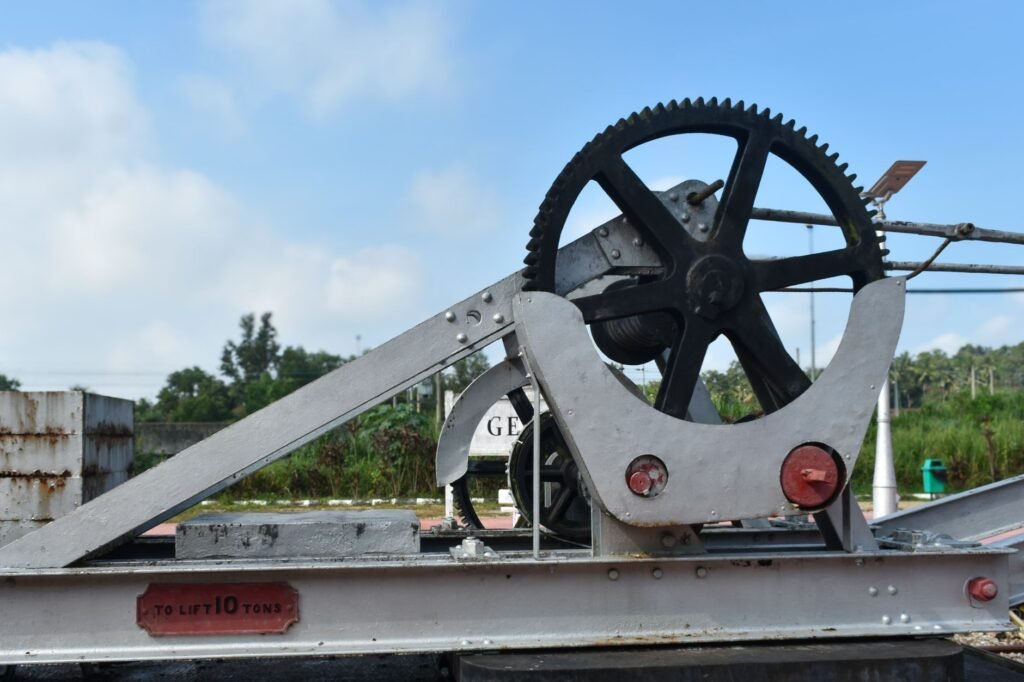 Close-up of a metal gear mechanism used for lifting 10 tons outdoors on a sunny day.